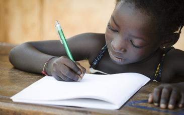 Young African girl writing in workbook