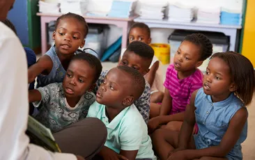Teacher reading book to elementary school children in class