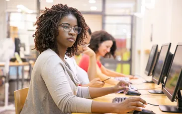 Young woman at row of computers