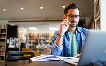 Researcher in library on laptop