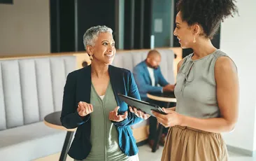 Two women colleagues walking and talking