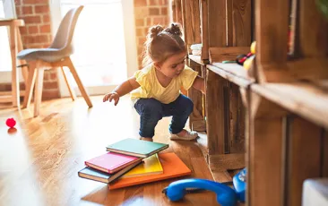 Toddler pulling books off shelves