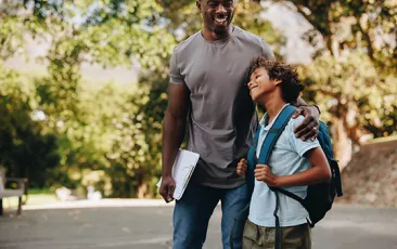 Happy student and teacher standing together outdoors