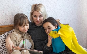 Ukrainian woman reading with daughters