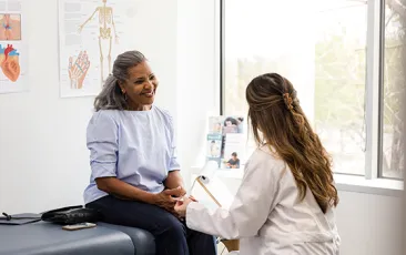 Female doctor talks to her senior adult patient about preventative lab work she should have completed