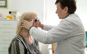 Optometrist adjusting test frame for patient