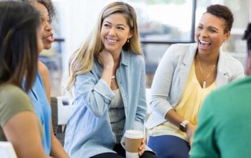 Educators meeting in a circle and laughing