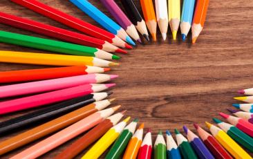 Colorful pencils lined up in a circle pointing to the center.
