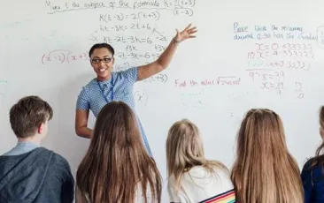 teacher pointing to a whiteboard