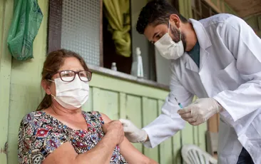 doctor giving shot to woman in rural setting