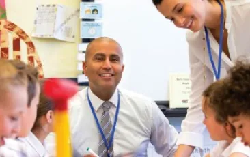 Two educators working in a classroom with elementary school students