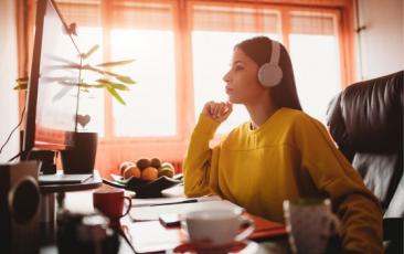 teacher seated at a desk wearing headphones