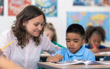 teacher working with elementary school student