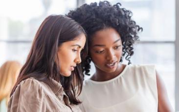 two women looking at a tablet together