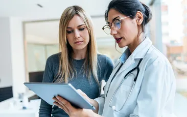 doctor talking while explaining medical treatment with digital tablet to patient in the consultatio