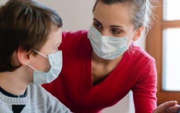 teacher and student with masks talking