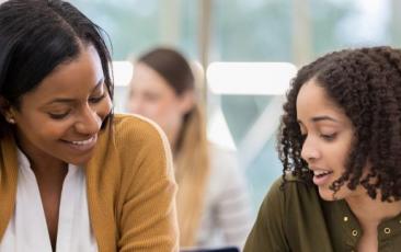 Two teachers talking at a table