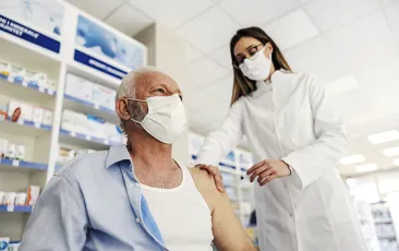 Pharmacist giving shot to man