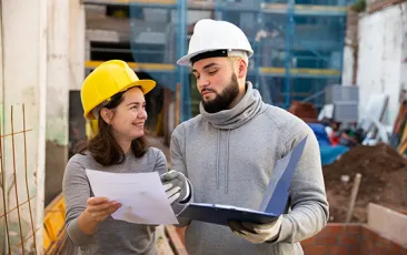 apprentice and supervisor talking in hardhats