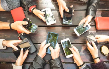circle of hands holding cell phones