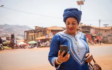 woman in traditional african dress looking at phone