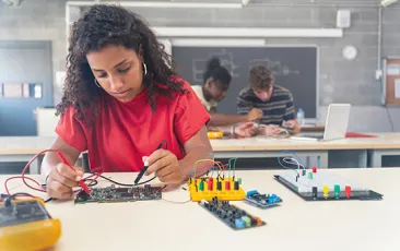 female high school student working on robotics project