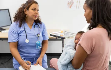 woman with newborn at doctor visit