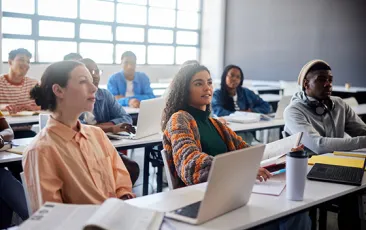 Adult students in classroom with laptops
