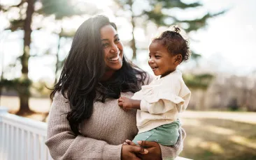 Loving mom holding baby outside