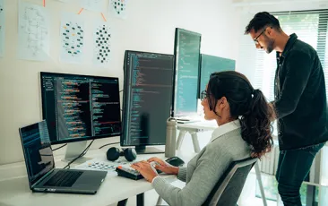 Programmers working together at multiple computers