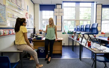 Teachers discussing lesson plans in a classroom