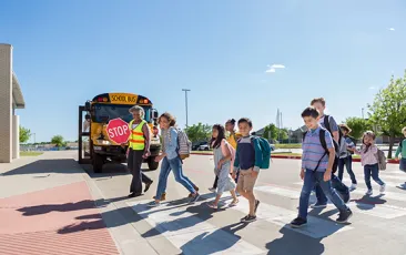 Students entering school with crossing guard