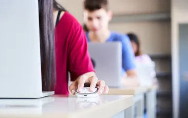 Female student clicking a mouse