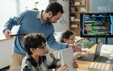 Teacher with young computer science students