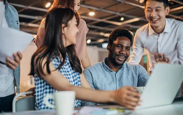 Diverse happy colleagues at a laptop