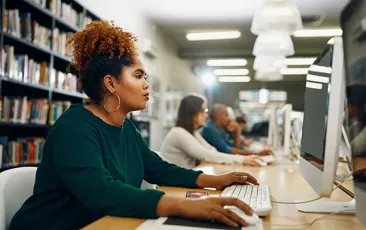 Young woman studying on computer in the library