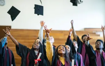 High school graduates throwing caps in the air