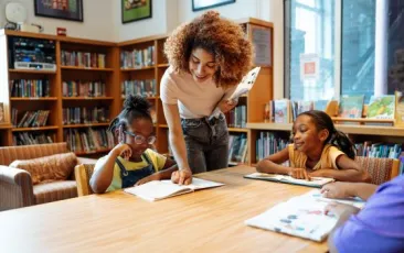 Teacher helping student in library