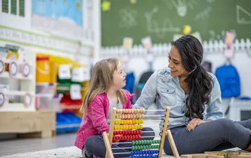 Young special education student with teacher in classroom