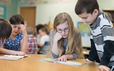 Elementary kids working together with workbooks