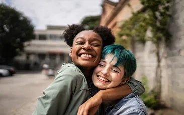 Happy teens hugging outside
