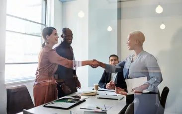 Business colleagues shaking hands in sunny room