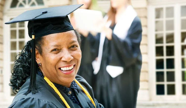 Older African American graduate in cap and gown