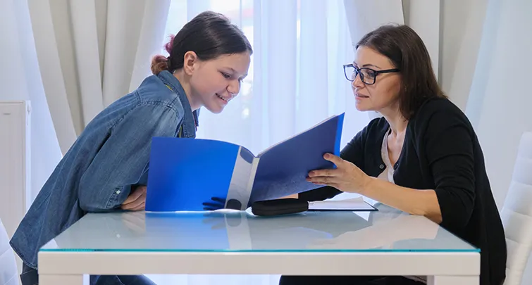 Teacher and student looking at folder