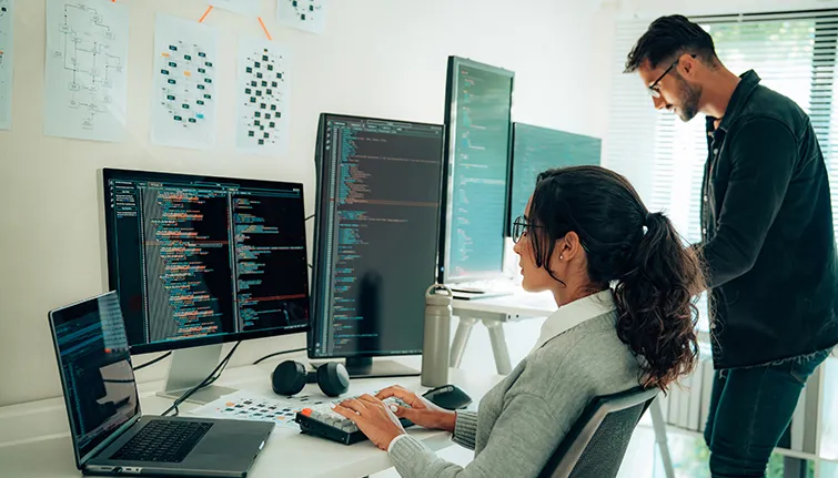 Programmers working together at multiple computers