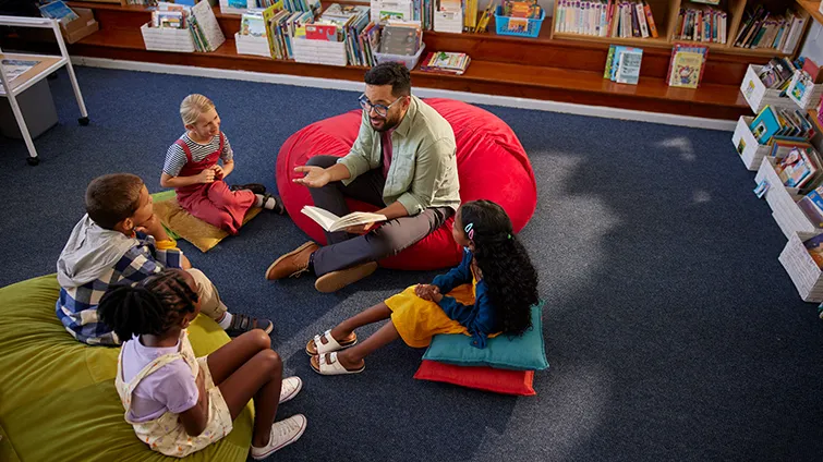 Teacher in library with young students