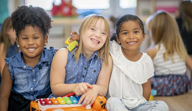 Young children hugging in a classroom