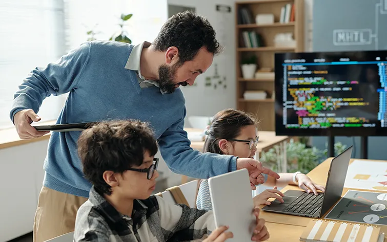 Teacher with young computer science students