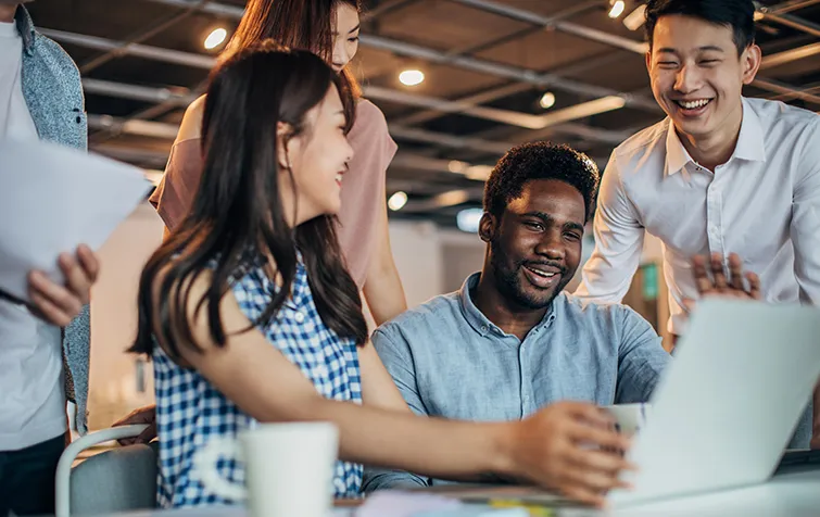 Diverse happy colleagues at a laptop