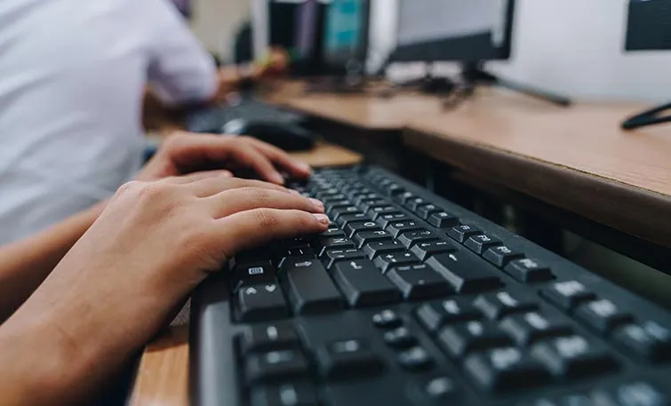 Hands at a computer keyboard